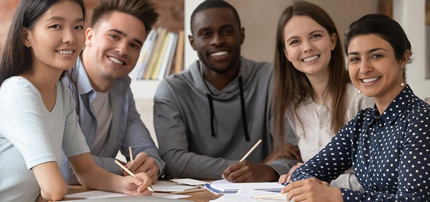 A group of students writing at a table.