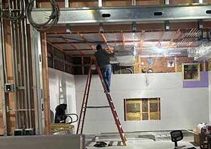 Man on ladder working on MRI room.